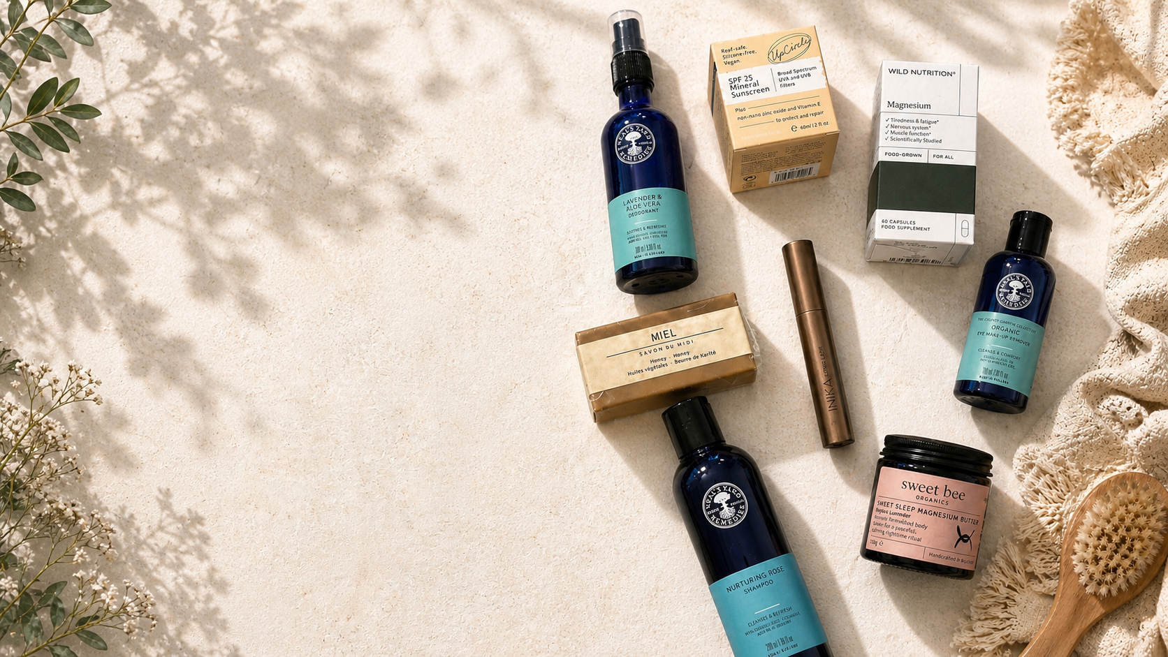 Collection of skincare and hair care products on a light surface with natural elements.
