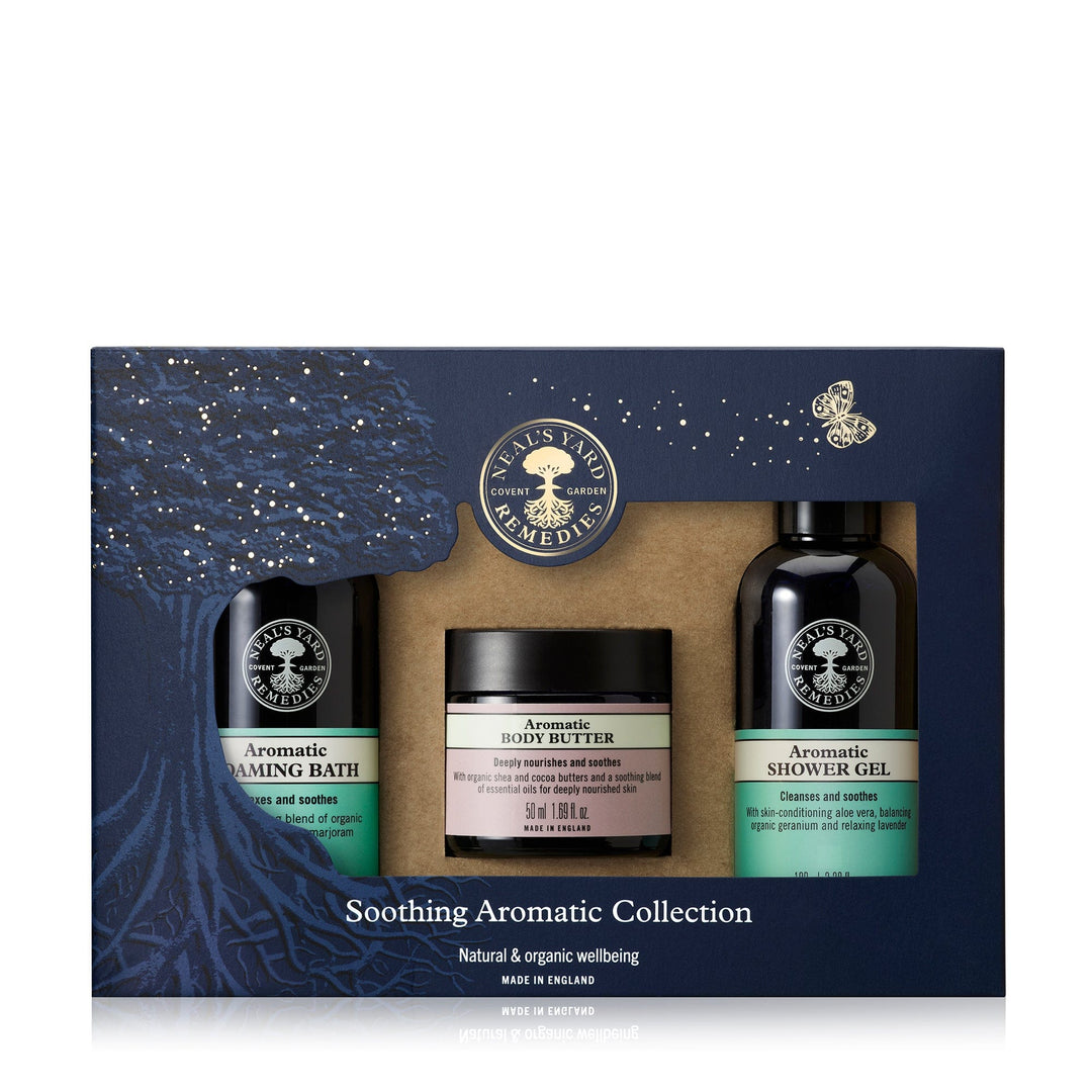A product image featuring a 'Soothing Aromatic Trio' collection which includes aromatic foaming bath, body butter, and shower gel. The items are packaged in a box with a window displaying the products.