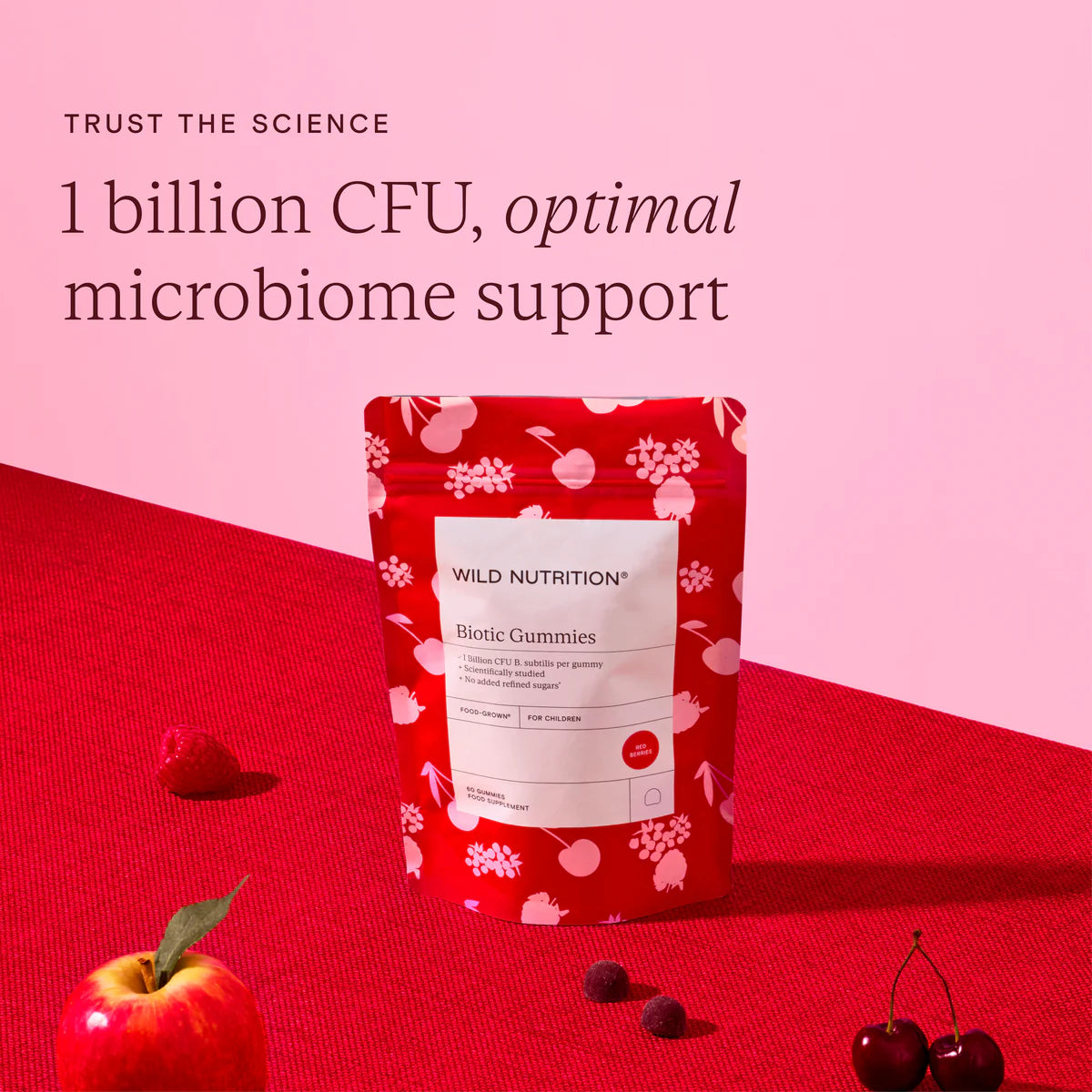 Red package of Wild Nutrition Biotic Gummies on a red and pink background with text about CFU and microbiome support.